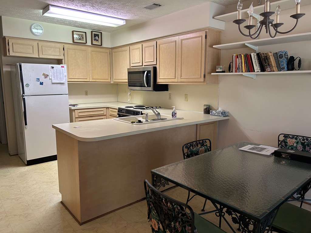 4151 Anglin Road, Unit 22C Columbus, GA 31907 - Photo 10 of 27 a kitchen with stainless steel appliances granite countertop a refrigerator a stove a sink dishwasher and white countertops with wooden floor
