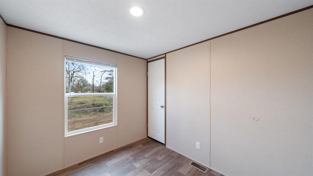 721 Queens Drive Tool, TX 75143 - Photo 18 of 30 a view of an empty room with wooden floor and a window