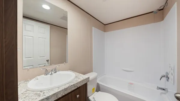 a bathroom with a granite countertop sink a toilet and shower
