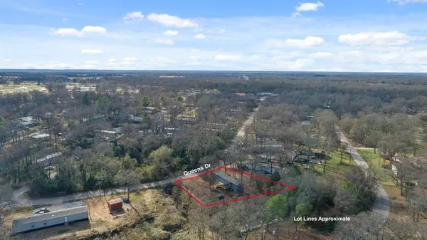 an aerial view of a house with a yard and large trees