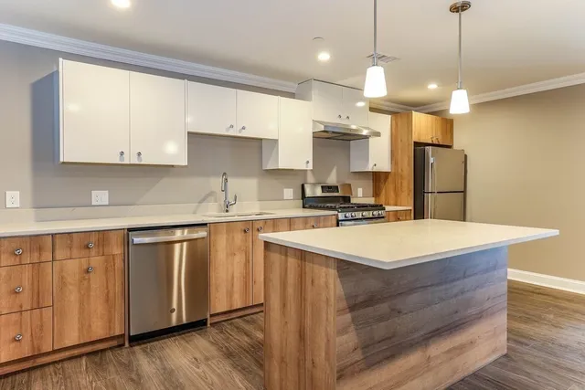 a kitchen with kitchen island a sink stainless steel appliances and cabinets
