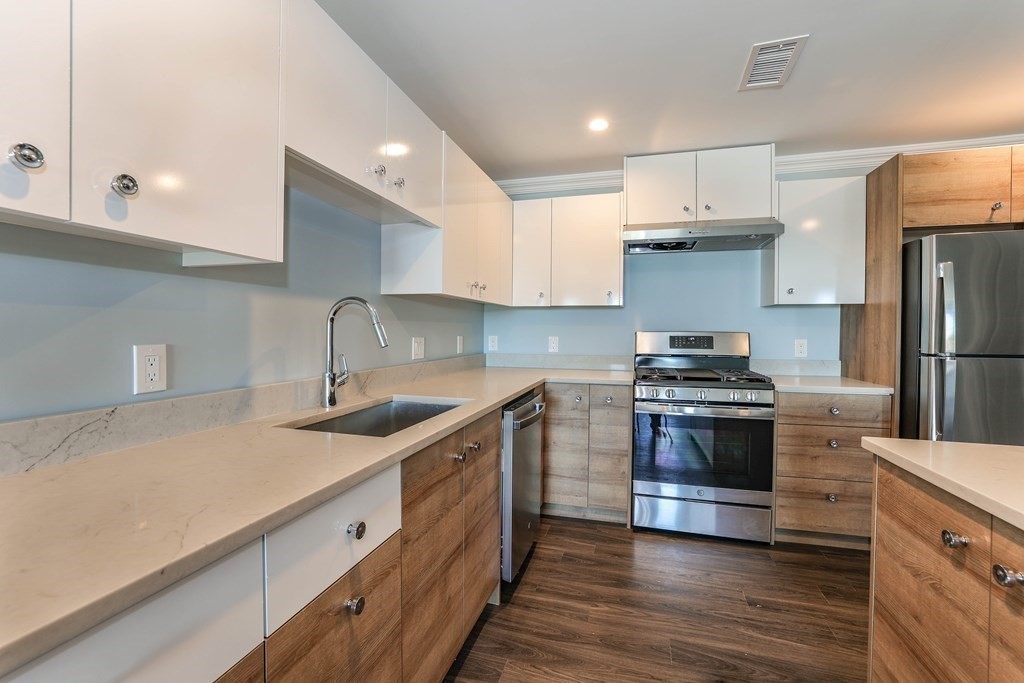 918 Providence Highway, Unit 314 Dedham, MA 02026 - Photo 2 of 10 a kitchen with stainless steel appliances granite countertop a sink stove and refrigerator