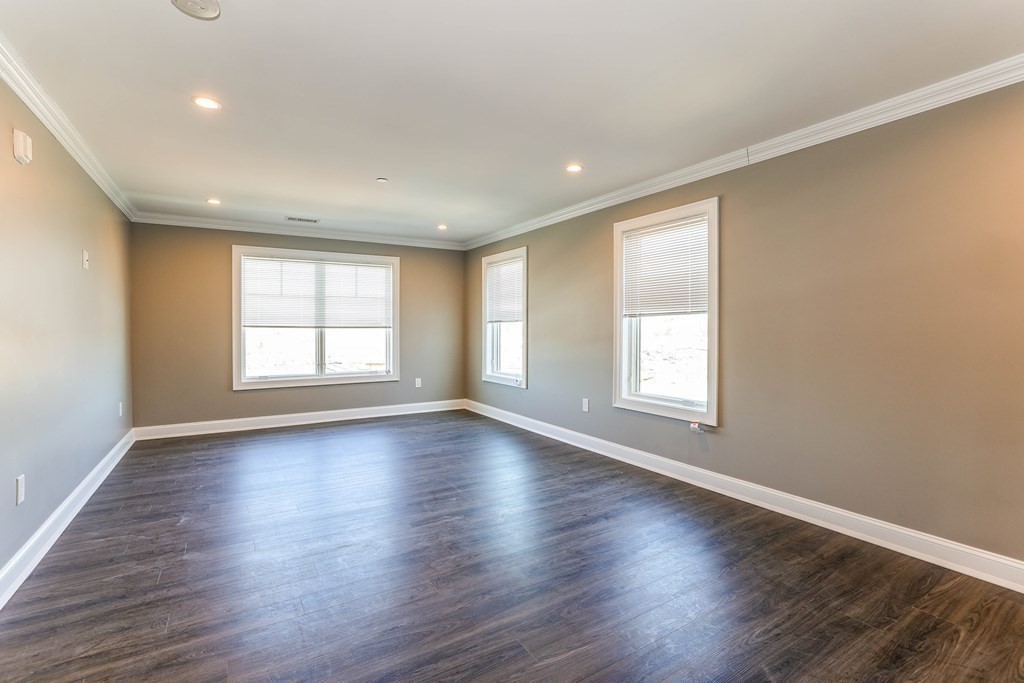 918 Providence Highway, Unit 314 Dedham, MA 02026 - Photo 5 of 10 an empty room with wooden floor and windows