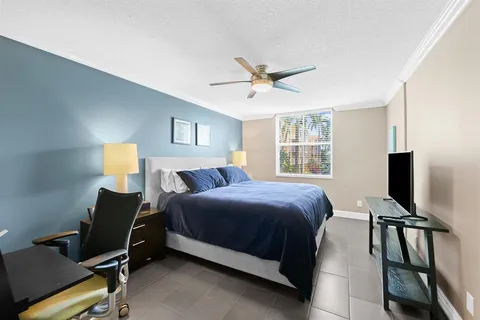 a bedroom with a bed tv and a window