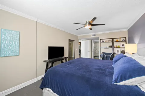 a spacious bedroom with a bed and a flat screen tv