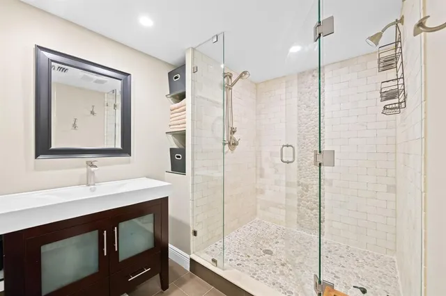 a bathroom with a double vanity sink mirror and shower