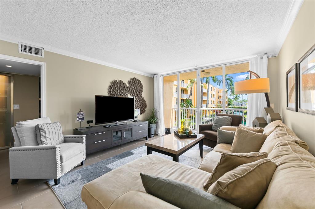 1341 Southeast 3rd Avenue, Unit 206 Dania Beach, FL 33004 - Photo 3 of 20 a living room with furniture and a flat screen tv