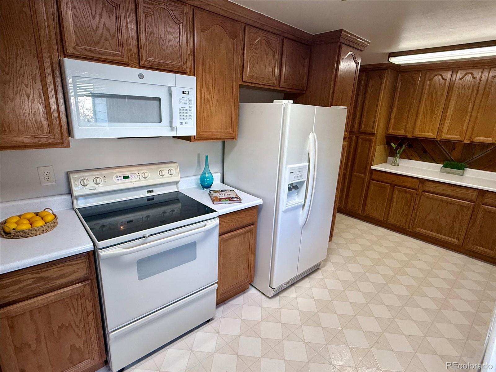 6272 South Garfield Drive Centennial, CO 80121 - Photo 11 of 37 a kitchen with stainless steel appliances a stove a refrigerator and a microwave