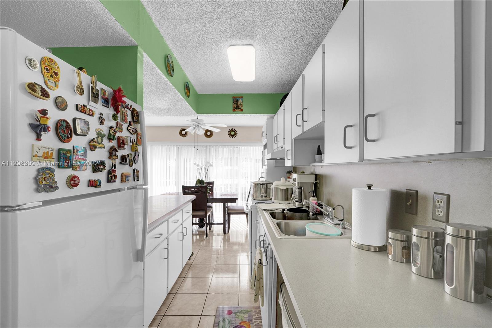 9331 Southwest 4th Street, Unit 118B Miami, FL 33174 - Photo 11 of 16 a kitchen with stainless steel appliances kitchen island granite countertop a sink and cabinets