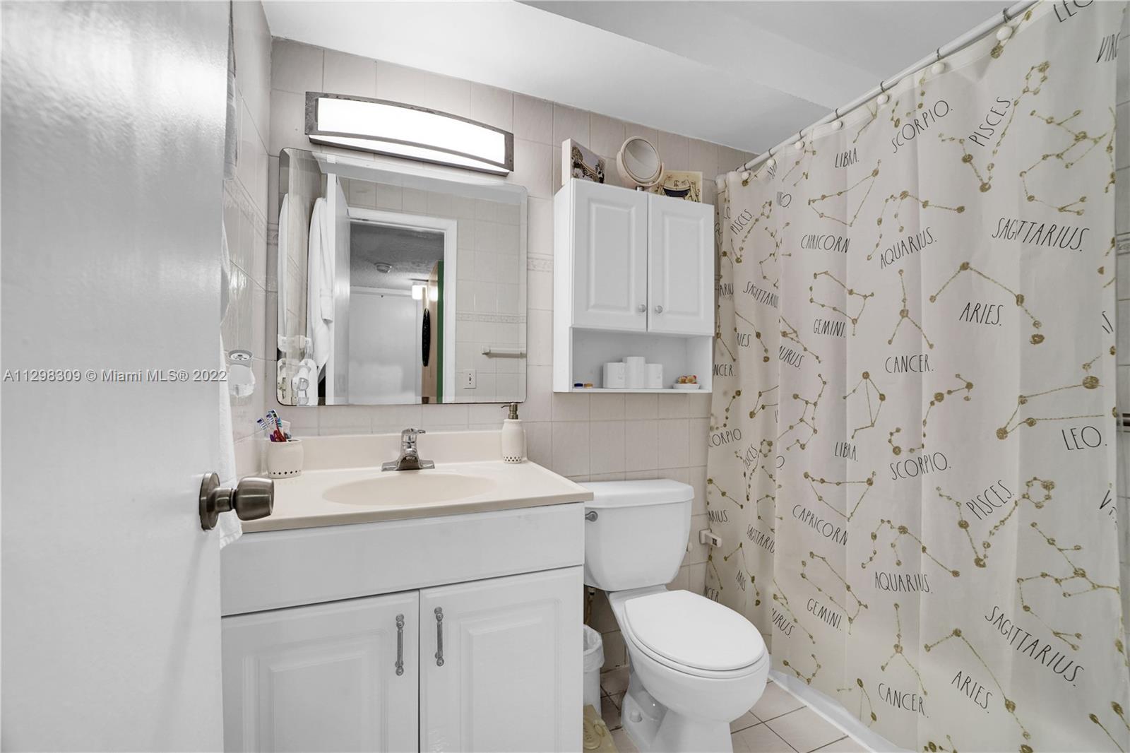 9331 Southwest 4th Street, Unit 118B Miami, FL 33174 - Photo 13 of 16 a bathroom with a sink a toilet and a mirror