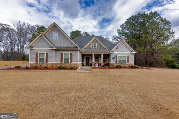 a front view of a house with yard and green space