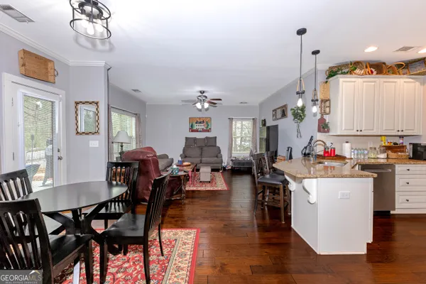 a view of a dining room and livingroom with furniture wooden floor a chandelier