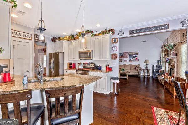 a view of dining room and livingroom with furniture wooden floor a chandelier