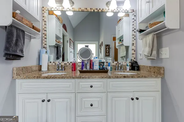 a bathroom with a granite countertop sink a large mirror and vanity