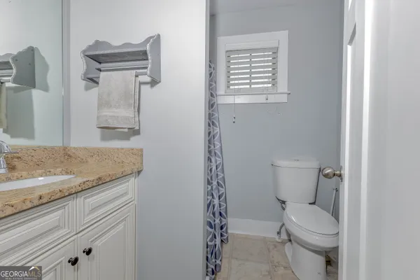 a bathroom with a granite countertop sink toilet and shower