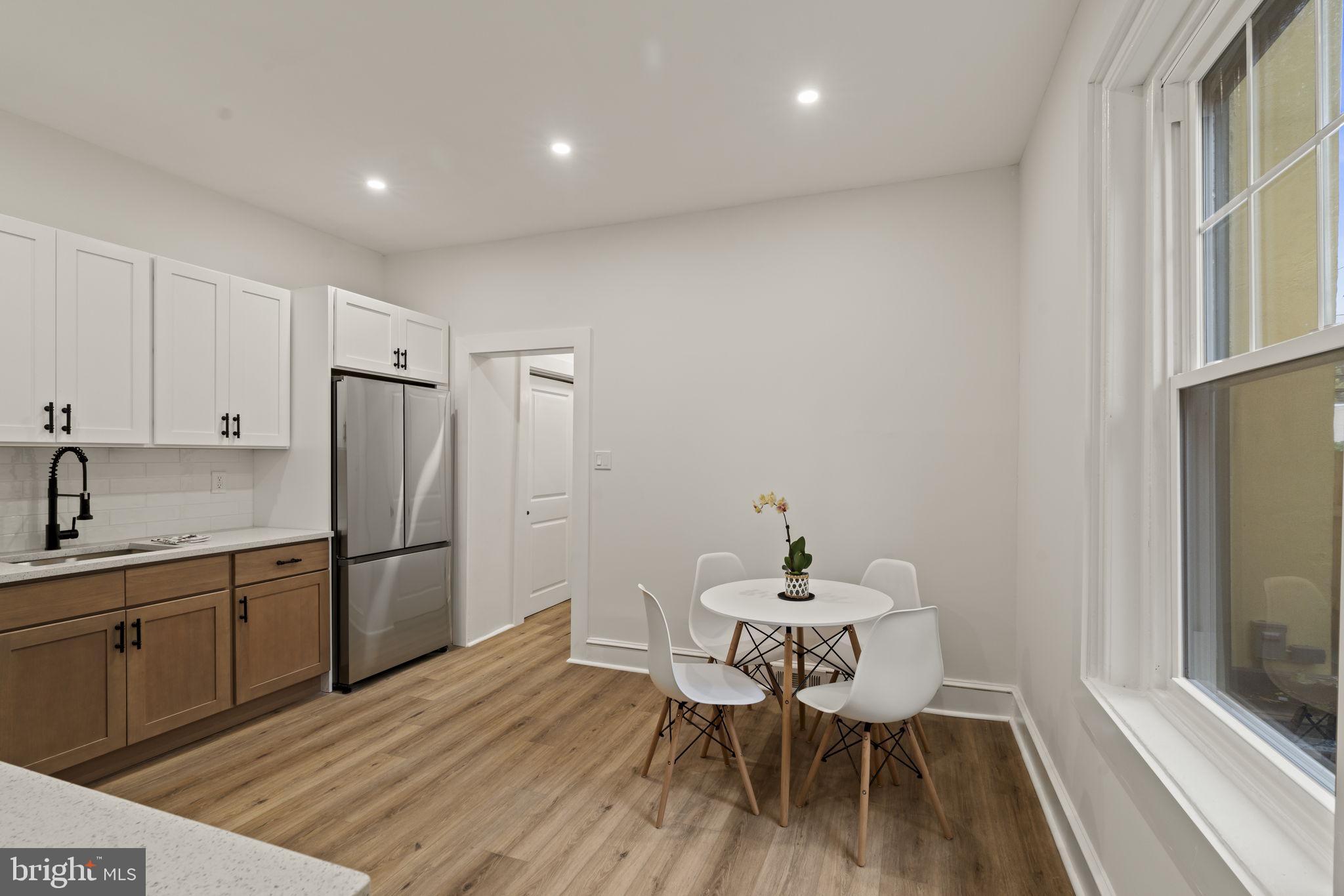 147 Harvey Street Philadelphia, PA 19144 - Photo 4 of 37 a kitchen with a dining table chairs and refrigerator