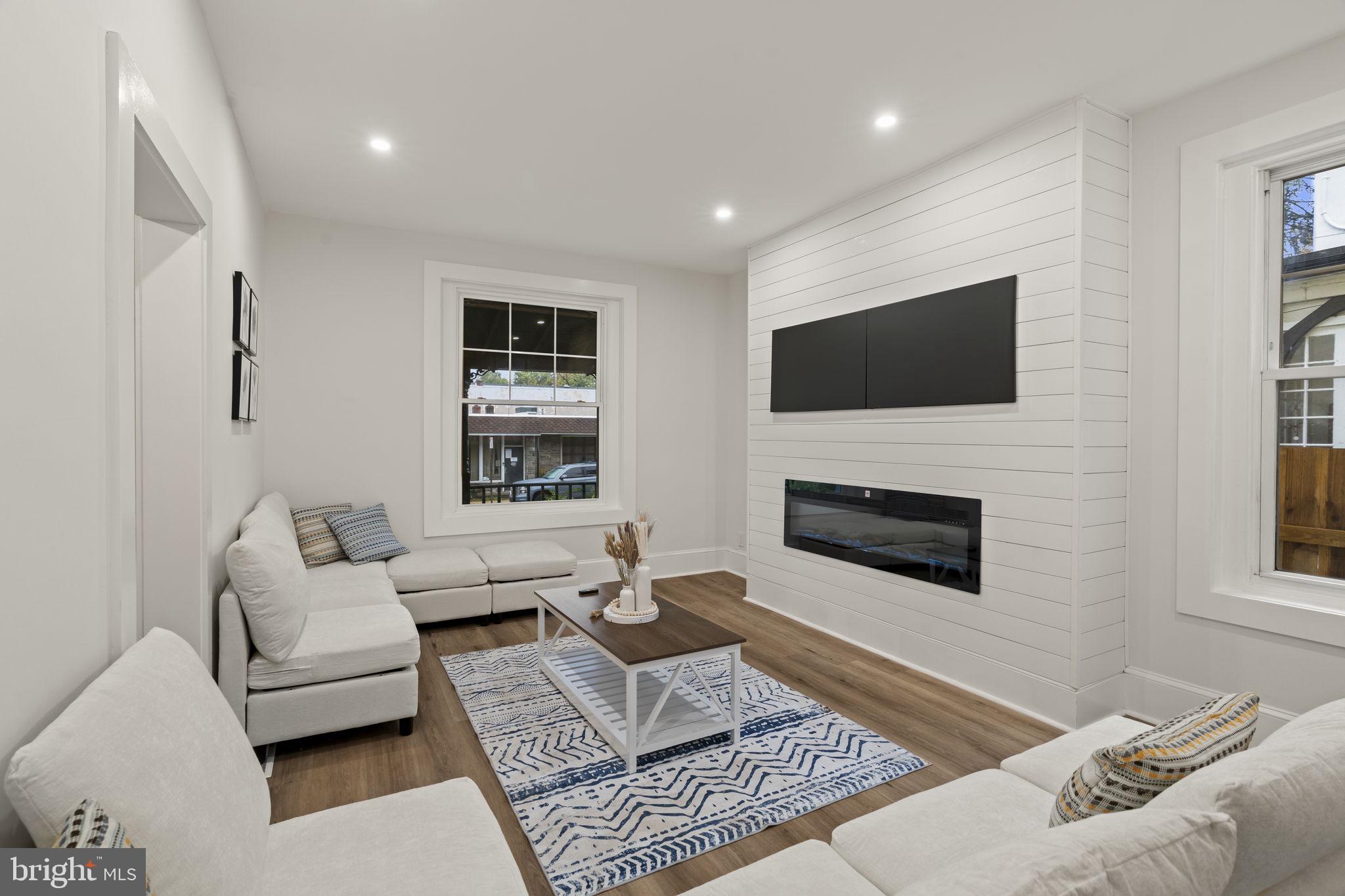 147 Harvey Street Philadelphia, PA 19144 - Photo 8 of 37 a living room with furniture a flat screen tv and a fireplace