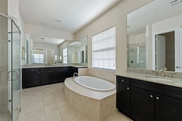 a bathroom with a granite countertop sink a mirror a shower and a bathtub