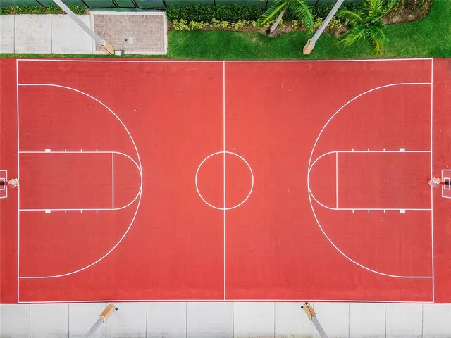 an aerial view of a tennis ground and a cars park