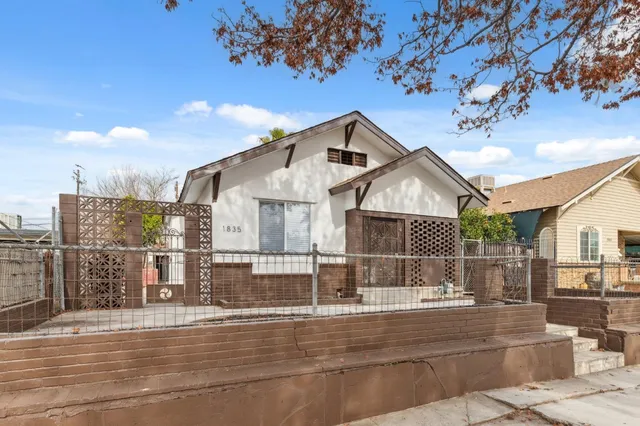 a view of a white house next to a road with city view