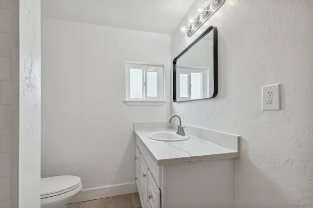 a bathroom with a toilet a sink and mirror