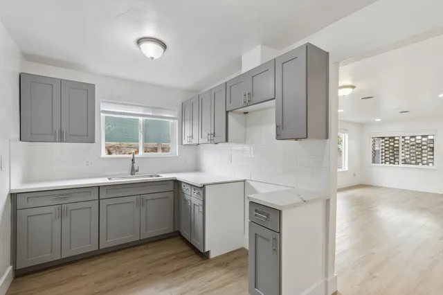 a kitchen with a sink cabinets and wooden floor