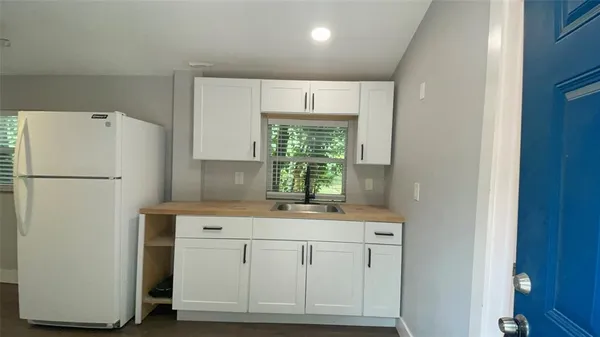 a kitchen with a white cabinets and a refrigerator