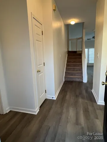 a view of a hallway with wooden floor and entryway