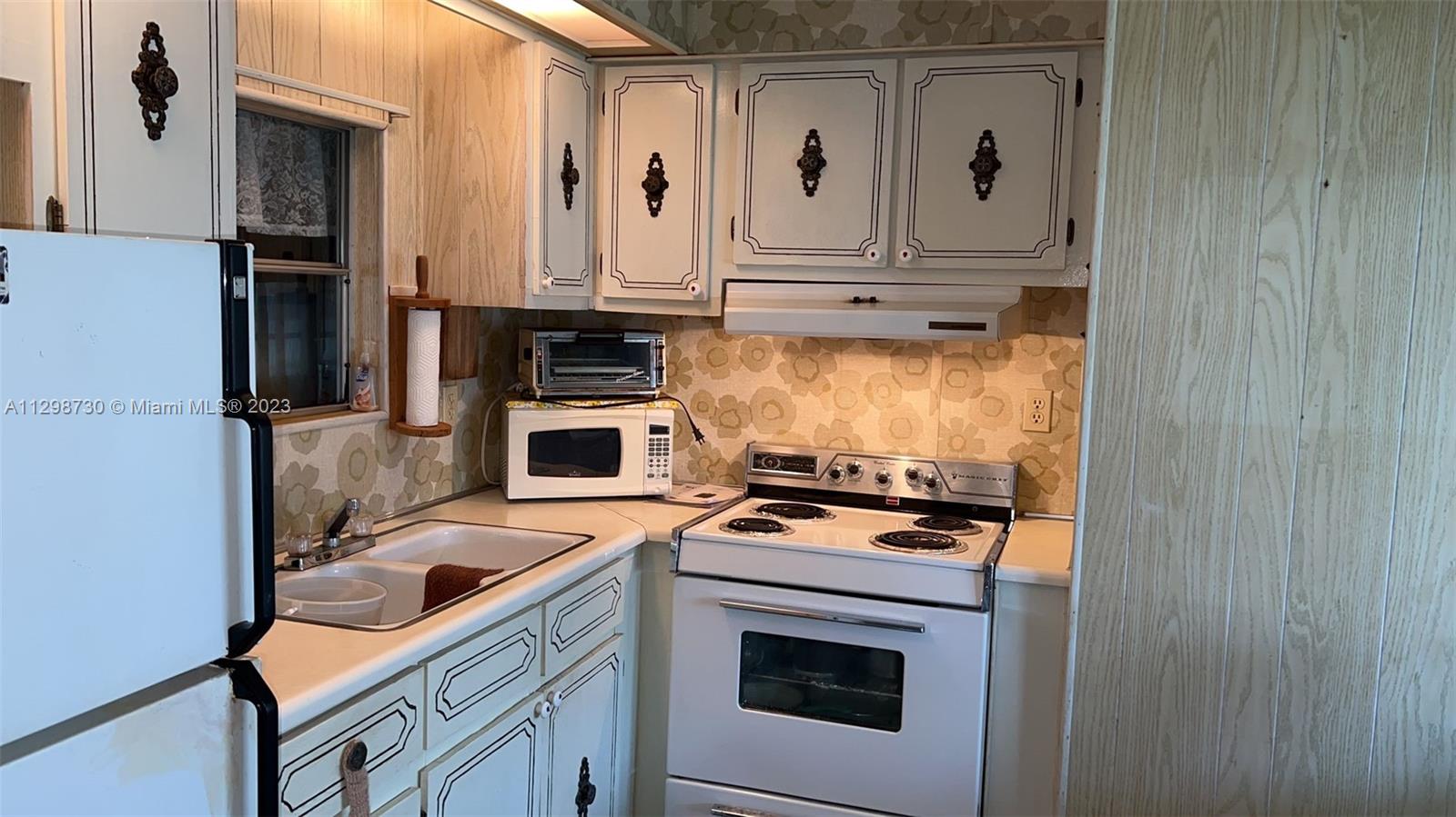 3502 Delaware Sebring, FL 33870 - Photo 9 of 21 a kitchen with stainless steel appliances granite countertop a stove and a refrigerator with white cabinets