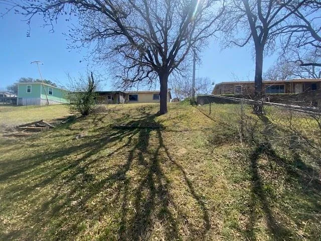a view of a yard with wooden fence