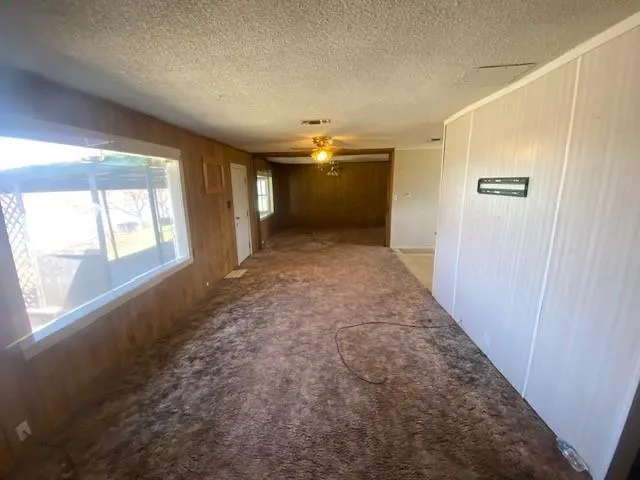 en empty room with windows and chandelier