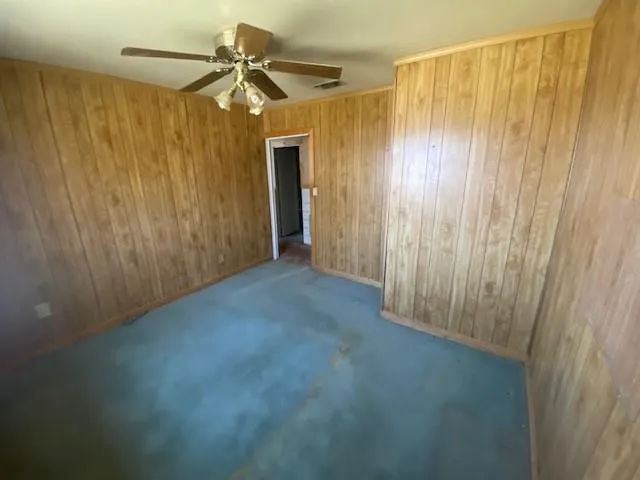 en empty room with windows and fan