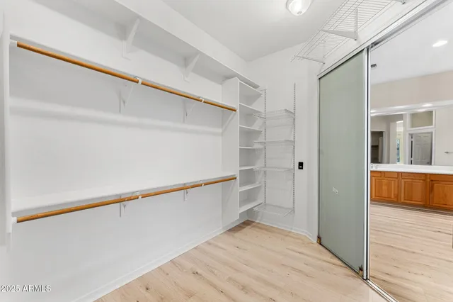 an empty room with wooden floor and ceiling fan