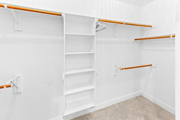 a view of walk in closet with empty racks