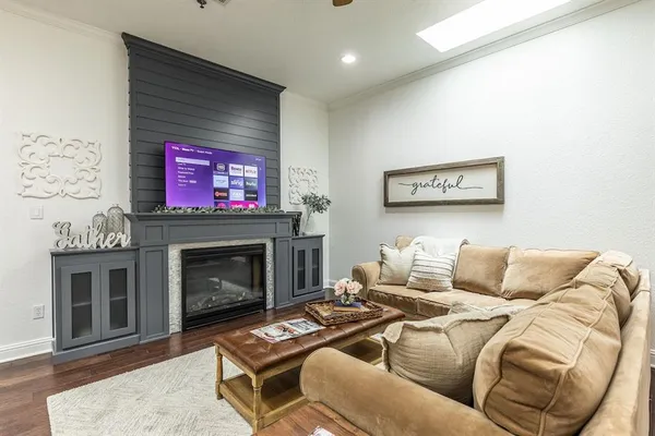 a living room with furniture a flat screen tv and a fireplace