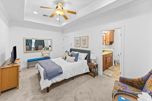 a bedroom with a bed couch and a flat tv screen