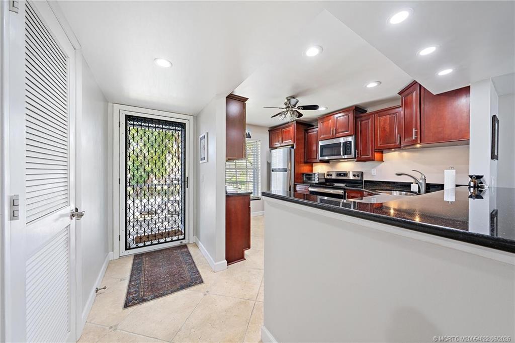 1862 Southwest Palm City Road, Unit 203 Stuart, FL 34994 - Photo 5 of 39 a kitchen with stainless steel appliances granite countertop a refrigerator a sink and a stove