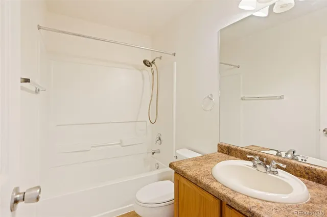 a bathroom with a granite countertop sink toilet and shower