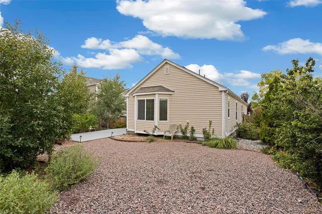 a backyard of a house with plants and trees
