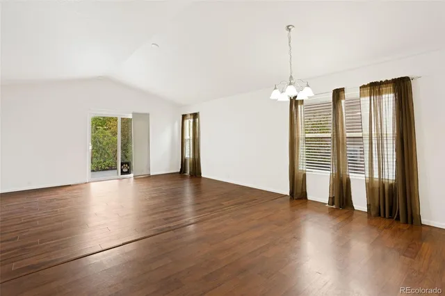 a view of a livingroom with wooden floor and a ceiling fan