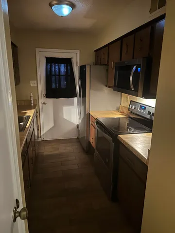 a kitchen with stainless steel appliances granite countertop a refrigerator and a stove