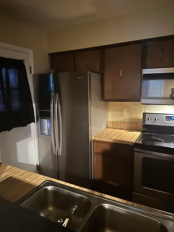 a kitchen with stainless steel appliances granite countertop a refrigerator and a stove