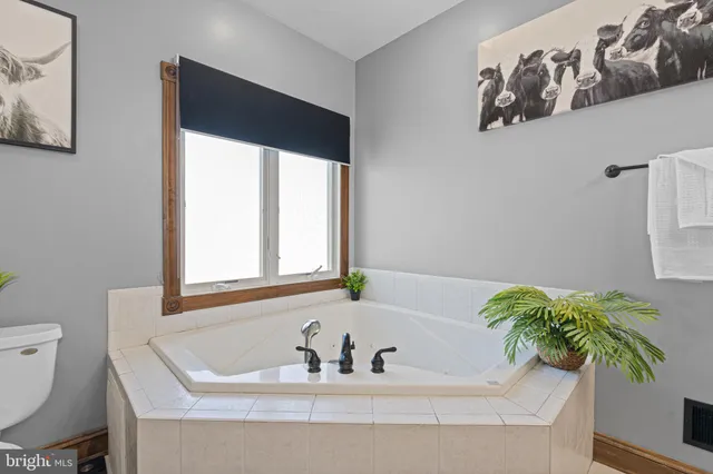 a bath tub sitting in a bathroom next to a blue sink