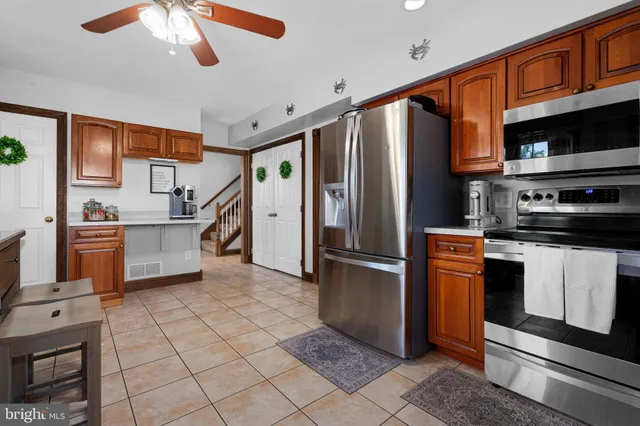 a kitchen with stainless steel appliances granite countertop a refrigerator a stove and a sink with cabinets