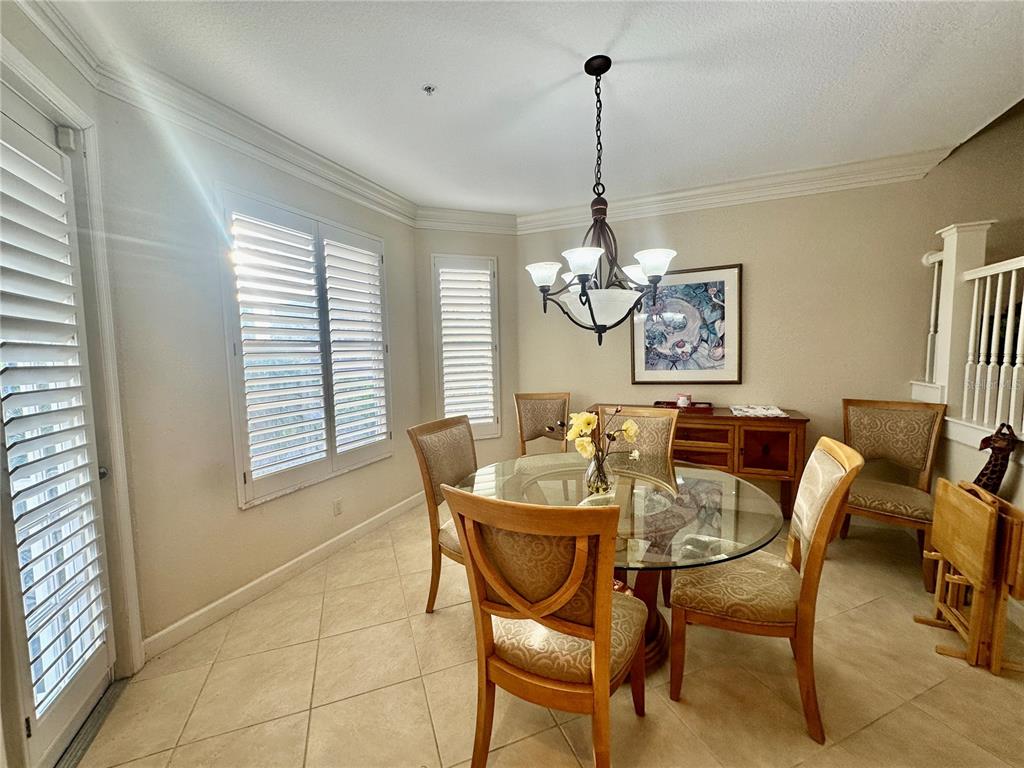 135 Shoals Circle North Redington Beach, FL 33708 - Photo 26 of 80 a view of a dining room with furniture a chandelier and large windows