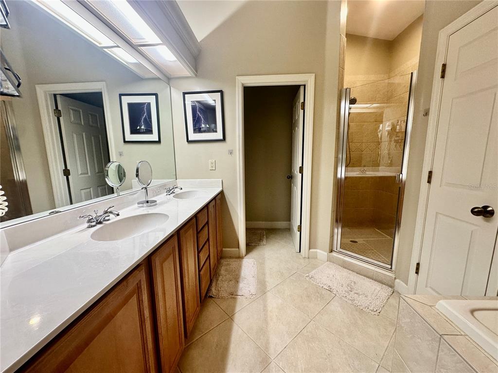 135 Shoals Circle North Redington Beach, FL 33708 - Photo 63 of 80 a en suite bathroom with a double vanity sink mirror and shower