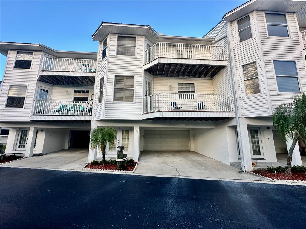 135 Shoals Circle North Redington Beach, FL 33708 - Photo 79 of 80 a view of a white building with many windows and a yard