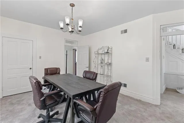 a view of a dining room with furniture and chandelier