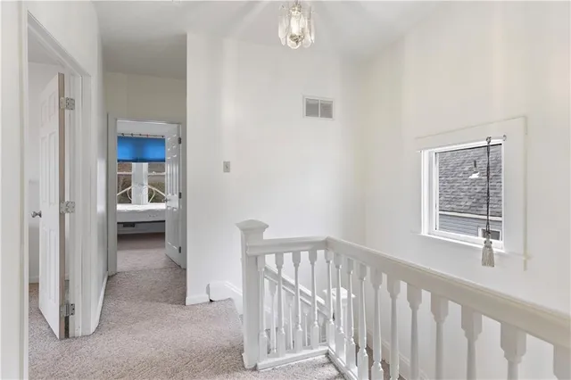 a view of a hallway with bathroom and wooden floor