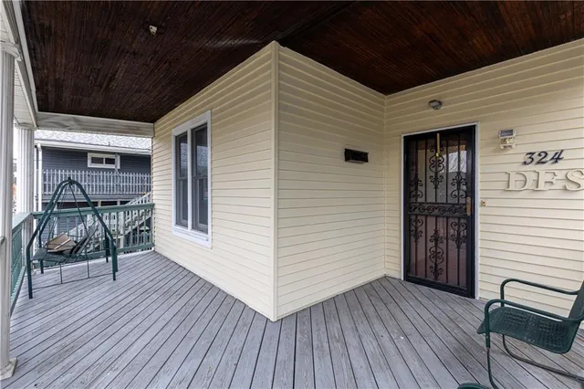 a view of a patio with table and chairs with wooden floor and fence